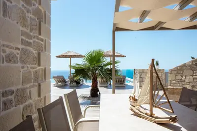 a room with a view of the ocean and a table and chairs at Flower Village in Chania Town