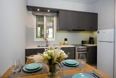 a kitchen with a table with a vase of flowers at Inner City Retreat Apartment in Chania Town
