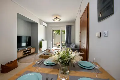 a living room with a table and a television at Inner City Retreat Apartment in Chania Town