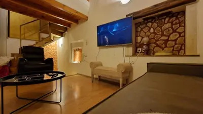 a living room with a tv and a couch and a table at Traditional 3 Story Townhouse ,Batta Hanem in Chania Town