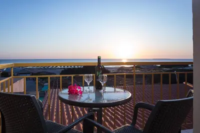 a table with a bottle of wine and two glasses at En Plo Beachfront Rooms in Falasarna