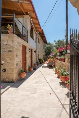 a patio with potted plants and a fence at Anthea Cottage in Kaloudhianá