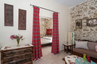 a living room with red curtains and a couch at Kantoni traditional house in Maláthiros