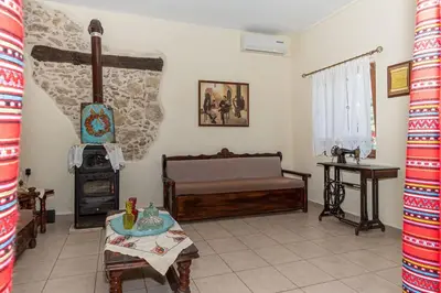 a living room with a bed and a stove at Kantoni traditional house in Maláthiros