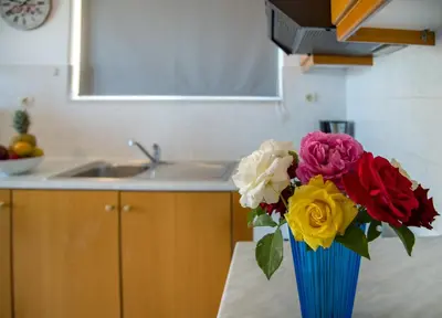 a blue vase with flowers on a table in a kitchen at Casa Di Halepa in Chania Town