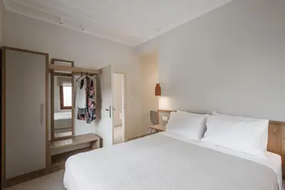 a bedroom with a white bed and a mirror at Villa Methexis in Arménoi