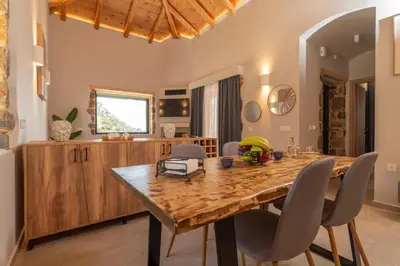 a dining room with a wooden table and chairs at Place of the Gοds in Palaiochóra