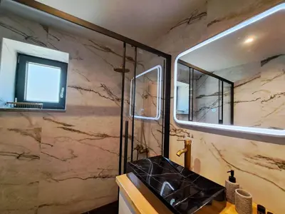 a bathroom with a sink and a shower with a mirror at Place of the Gοds in Palaiochóra