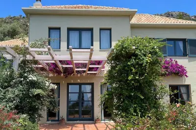 a house with a balcony on top of it at Staffed, unique and luxurious coastal villa in beautiful Anidri, Paleochora in Palaiochóra