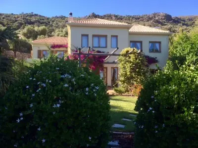 a large white house with trees in front of it at Staffed, unique and luxurious coastal villa in beautiful Anidri, Paleochora in Palaiochóra