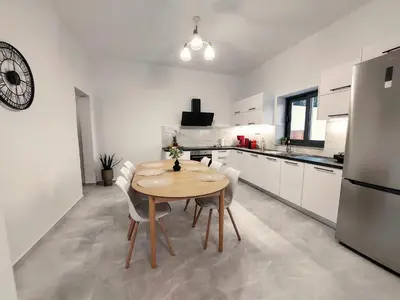 a kitchen with a wooden table and white cabinets at Blue Horizon Kissamos Apartment in Kissamos