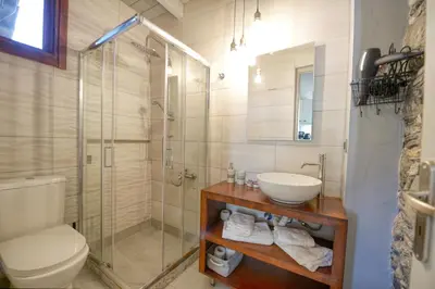 a bathroom with a shower and a sink and a toilet at Velanos Villas in Kefálion