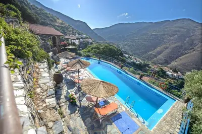a view of a swimming pool with umbrellas at Velanos Villas in Kefálion