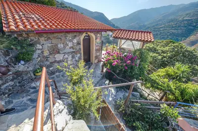 a stone house with a staircase leading up to it at Velanos Villas in Kefálion