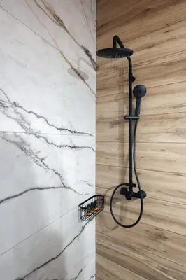 a shower with a black shower head in a bathroom at Villa Eliomylos in Souda