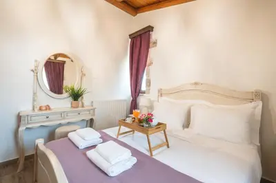 a bedroom with a bed with a table and a mirror at Villa Eliomylos in Souda