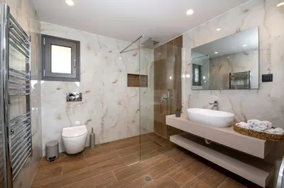 a bathroom with a sink and a toilet and a mirror at Armour Eclectic Villa in Afráta