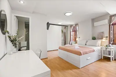 a white bedroom with a large bed in a room at Rodon maisonette in Chania Town