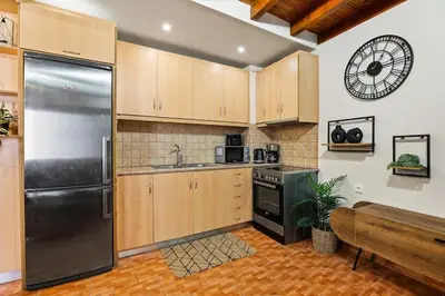 a kitchen with wooden cabinets and a stainless steel refrigerator at Rodon maisonette in Chania Town