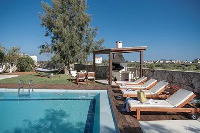 a swimming pool with lounge chairs and a gazebo at Villa Magia in Stérnai