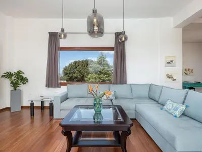 a living room with a blue couch and a table at Villa Magia in Stérnai