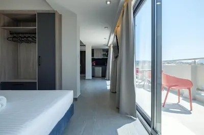 a bedroom with a bed and a balcony with a table at Sky-High Central Penthouse w. Stunning Views - 02 in Chania Town