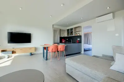 a living room with a couch and a table with chairs at Sky-High 70sqm Penthouse w. Stunning Views - 05 in Chania Town