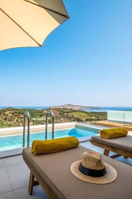 a hat sitting on a table next to a pool at Evora Suites in Chania Town