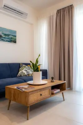 a living room with a blue couch and a coffee table at Evora Suites in Chania Town