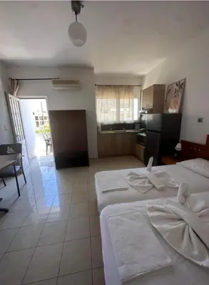 a hotel room with two beds and a kitchen at Nova Marine in Souda