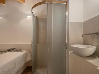 a bathroom with a glass shower and a sink at Theros Home in Chania Town