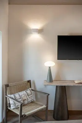 a room with a bench and a television on a wall at Theros Home in Chania Town