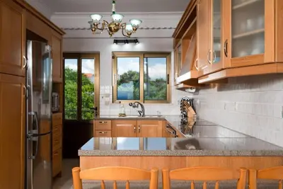 a kitchen with wooden cabinets and a counter top at Douranakis house Seaview Apartment in Chania Town