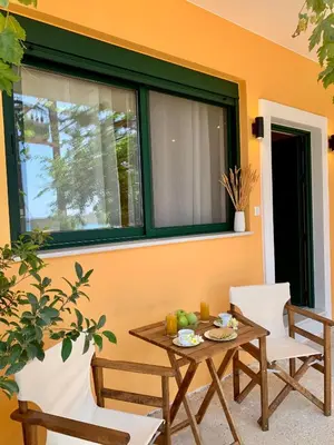 a patio with a table and chairs and a window at Paleochora Beach Studio (BRAND NEW) in Palaiochóra