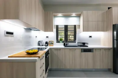 a kitchen with wooden cabinets and a bowl of fruit on a counter at Estia Comfort House in Chania Town