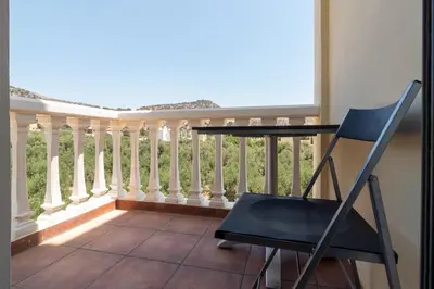 a blue chair on a balcony with a railing at Marika Seaside Villa in Yialós