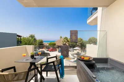 a balcony with a table and chairs and a view of a street at Elia Agia Marina Resort in Agia Marina Nea Kydonias