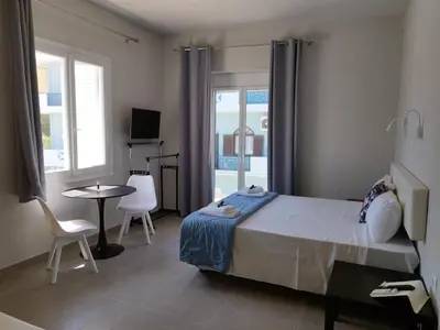 a bedroom with a bed and a table and chairs at Villa Katerina in Chania Town