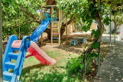 a playground with a slide and a tree at Villa Thalia Chania in Chania Town