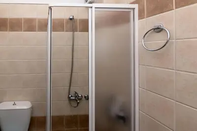 a shower stall with a toilet in a bathroom at Seaside Escape in Nopíyia
