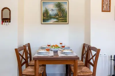 a wooden table with a bowl of fruit and wine glasses at Seaside Escape in Nopíyia