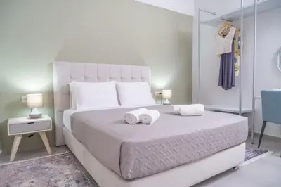 a bedroom with a white bed with two towels on it at Villa Emily in countryside in Chania Town