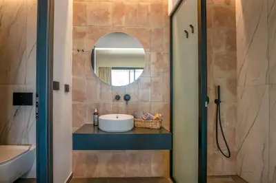 a bathroom with a sink and a mirror at Nusa Retreat - Seaview luxury residences - ideal for groups in Kissamos