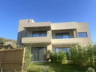 an apartment building in front of a blue sky at Nusa Retreat - Seaview luxury residences - ideal for groups in Kissamos