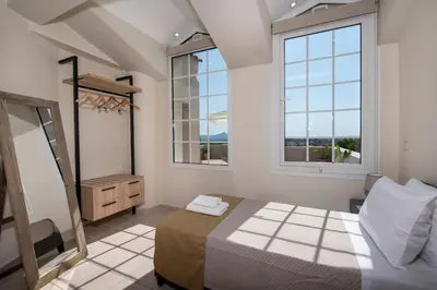 a bedroom with a bed and two windows at Villa Damant in Pithárion