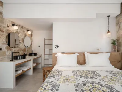 a bedroom with a bed and a sink and a mirror at La Canea Living in Chania Town