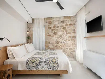 a bedroom with a bed and a stone wall at La Canea Living in Chania Town