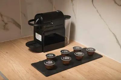 a coffee maker and thirteen cups on a black tray at Somine Apartment Chania in Chania Town