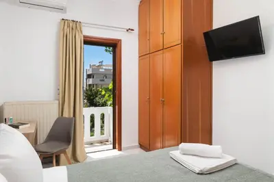 a bedroom with a bed and a tv and a window at Somine Apartment Chania in Chania Town