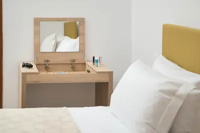 a bedroom with a bed and a mirror on a table at Somine Apartment Chania in Chania Town